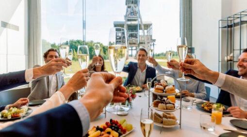 Gasten klinken met champagne tijdens een privé-event in Terhills Hotel met zicht op de mijnschacht